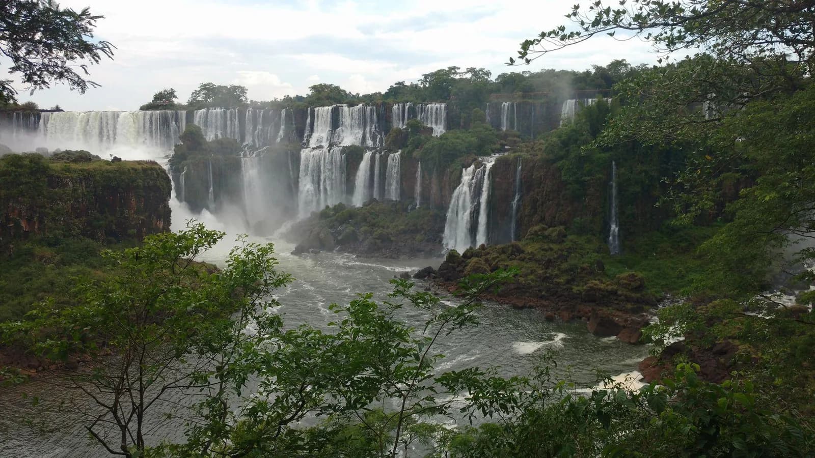 Iguazú’s broad cascades fall between green forest and mist.