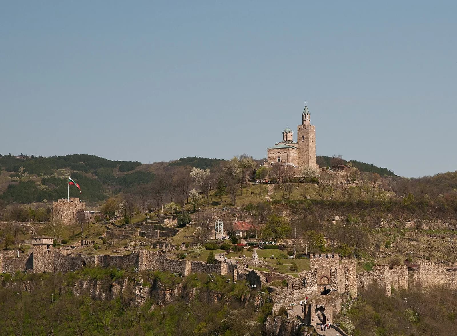 Tsarevets hill in Veliko Tarnovo with stone walls and towers on the slope and the Patriarchal Church on the summit