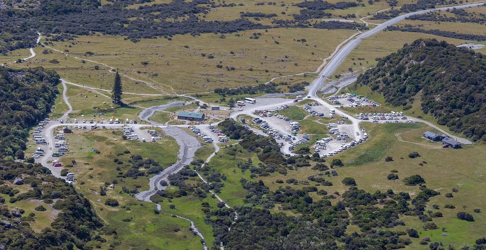 White Horse Hill campsite and car park seen from above, surrounded by valley slopes.
