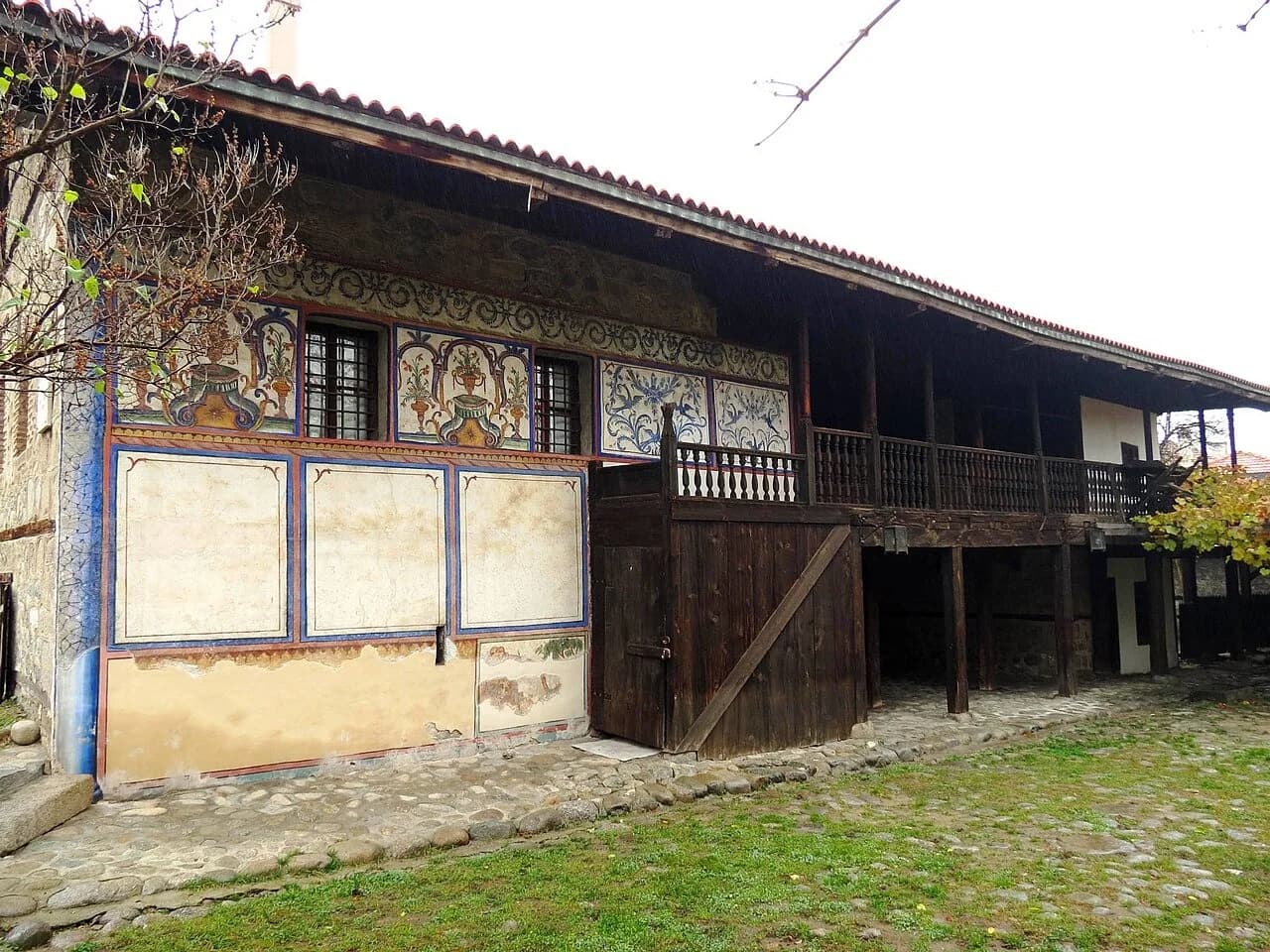 Painted exterior and wooden veranda of Velyanova House in Bansko