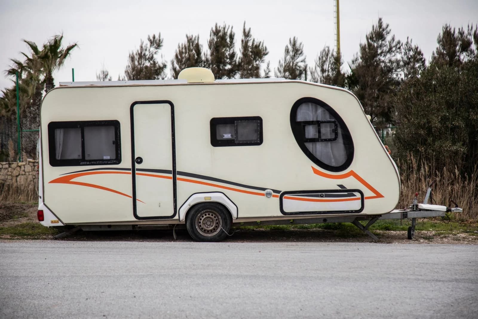 White caravan parked beside a road, with its tow coupling visible