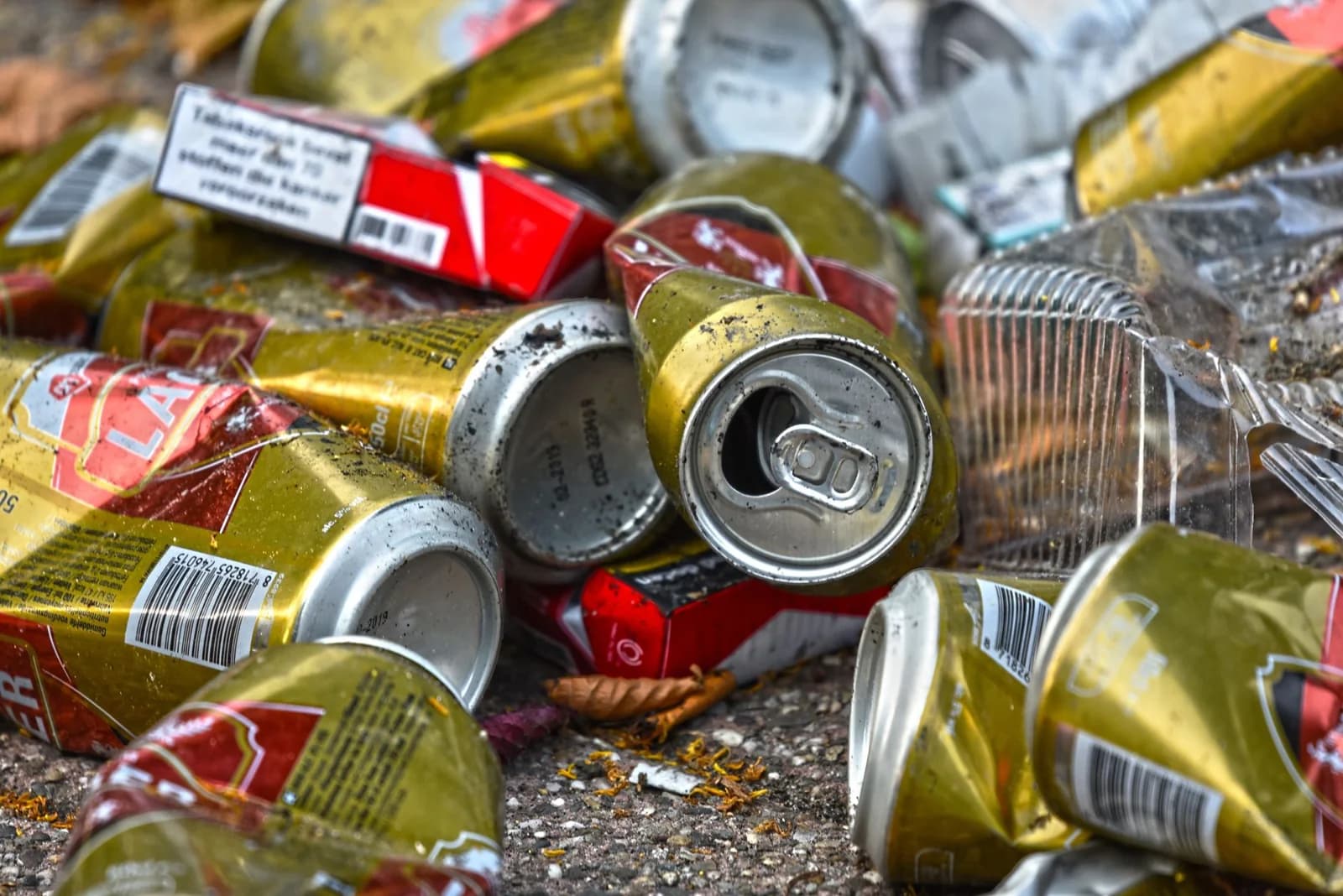 Crushed drink cans and a cigarette packet littering the ground