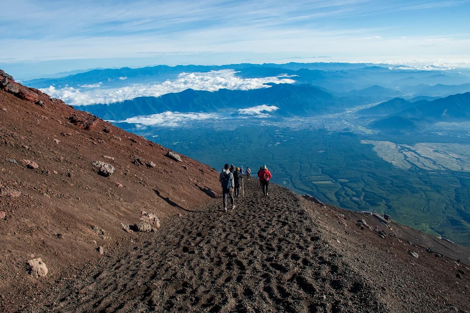 Hikers descending the volcanic slope on Mount Fuji’s Yoshida Trail